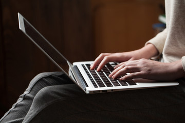 Wall Mural - woman hands using laptop at office desk, with copyspace in dark