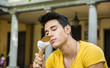 © theartofphoto - Attractive young man eating vanilla ice cream