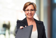 © asierromero - portrait of a mature business woman giving a book