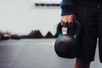 Wall Mural - Closeup of man holding heavy kettlebell