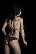 © Poulsons Photography - woman in a bikini on a black background from back head turned