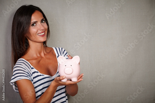 Fotografía Good-looking brunette lady holding a moneybox
