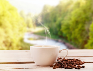 Poster - Cup of coffee on table on bright background