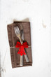 Weihnachtlich dekoriertes Besteck mit Serviette auf Holzuntergru