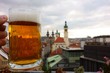 A fresh pint of Czech craft beer on a rooftop terrace in the center Prague, Czech Republic with many of the Prague landmarks appearing on the background on cloudy mid-October evening in 2015. 