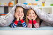 © spass - Two happy children lying under blanket