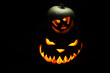Two pumpkins on Halloween together spooky and funny on black background
