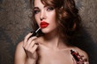 © blackday - Woman applying red lipstick