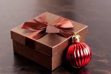 composition with Christmas ball and gift box on a black backgrou