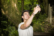 Young Man Taking Selfie with Cell Phone in Forest