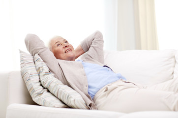 Wall Mural - happy senior woman resting on sofa at home