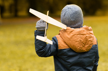 happy little boy playing with toy plane outdoors