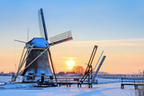 Beautiful sunset behind an old mill in winter in the Netherlands