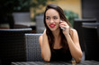 © Andre Ila - Woman using mobile phone in cafe