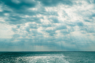 Wall Mural - clouds over the ocean with sunbeams