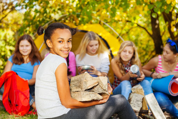 cute african girl holding kindling wood sitting