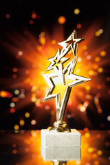 Wall Mural - gold stars trophy against shiny sparks background