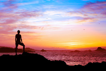 wellbeing concept, silhouette of person enjoying beautiful sunset with view of ocean