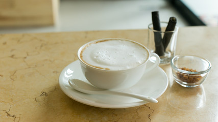 hot art latte coffee in a cup on wooden table and coffee shop bl