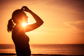 Wall Mural - woman open arms under the sunset at sea