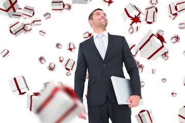 Poster - Composite image of businessman looking up holding laptop