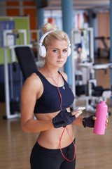 Wall Mural - woman with headphones in fitness gym