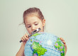 © Myst - beautiful cute little girl looking through magnifying glass at globe