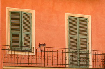 old wooden shutters on the window and door leading to an exterior balcony of  mediterranean urban house