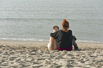 Love. Young beautiful girl hugging her dog sitting in front of t