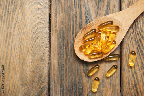 Fotografia fish oil capsules in a spoon