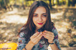 © kegfire - Closeup of beautiful teenage girl holding a tartatel with berries outdoors. Cute hipster brunette young woman on autumn day