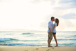 © EpicStockMedia - Young Couple Kissing on the Beach at Sunset