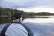 © Jne Valokuvaus - An elderly man is sitting on a bench by the sea and remembering the old times. The man is composed on the left side and he is wearing a cap and a jacket.