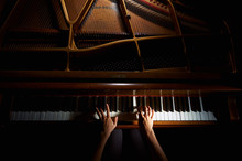Woman's Hands On The Keyboard Of The Piano In Night Closeup