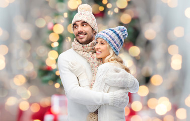 Canvas Print - smiling couple in winter clothes hugging