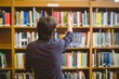 © WavebreakMediaMicro - Student picking a book from shelf in library