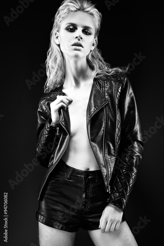 Nowoczesny obraz na płótnie Daring girl model in black leather dress, style of rock on naked body, dark makeup and wet hair. Black-and-white image.