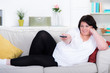 © Racle Fotodesign - Dicke Frau mit Fernbedienung auf der Couch