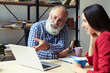 © ArtFamily - colleagues looking at laptop in office