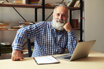 successful senior man sitting at his working place