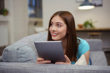 Wall Mural - frau liegt gemütlich auf dem sofa und liest am tablet-pc