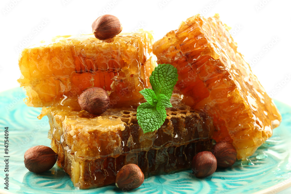 Honeycombs and nuts on plate isolated on white
