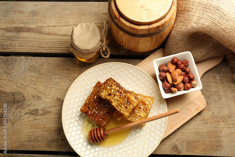 Honeycombs on plate on wooden background