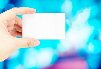 Hand holding blank business card with blur blue bokeh light back