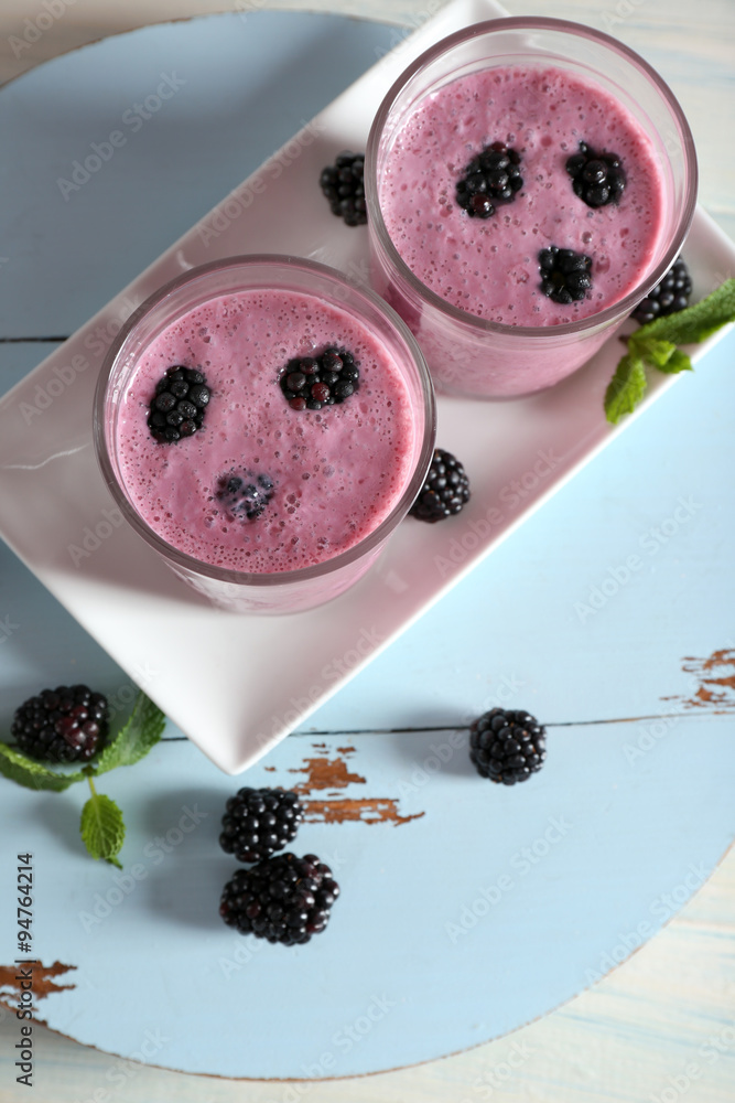 Delicious berry smoothie with blackberries on wooden table close up