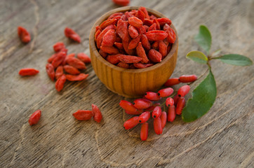 Wall Mural - barberries and goji berries on wooden background