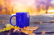 © Cristian Kerekes - Blue cup on wooden table with autumn blurred background