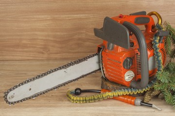 Chainsaw on a wooden background. Small saw for pruning. Tool for arborists.
