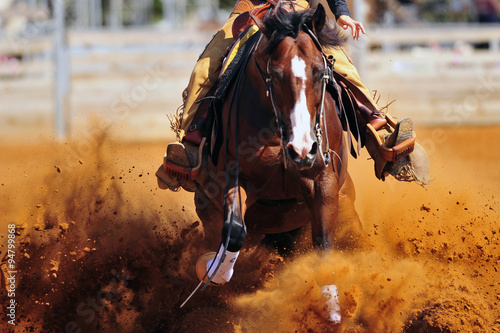 Foto-Tischdecke - A close up view of a rider sliding the horse in the dirt (von PROMA)