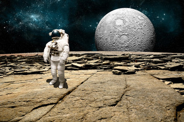 Wall Mural - a stranded astronaut surveys his situation on a barren moon - elements of this image furnished by na